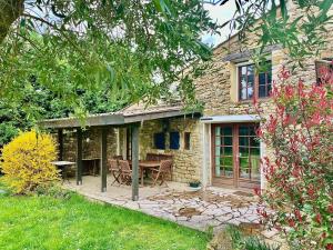 a stone house with a picnic table in the yard at GITE LA FREYDIERE in La Bégude-de-Mazenc