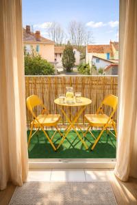 a table and chairs on a balcony with a table at Le Twins - Appartement de charme à Digoin in Digoin