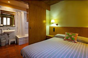 a bedroom with a bed and a sink and a tub at Hostal Victor in Oliana +54 photos