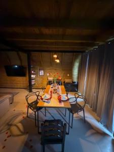 a dining room with a table and chairs in a room at Chalè Aurora do vale in Cobras