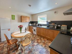 a kitchen with a table and chairs and a refrigerator at Uk47551 - Cree View Cottage in Newton Stewart