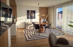 a living room with a table and chairs at "SONNENGRÜN" - Premium Apartments Seekirchen, Balkon in Seekirchen am Wallersee