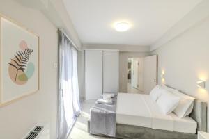 a white bedroom with a bed and a window at Villa Nazar in Xiropigado