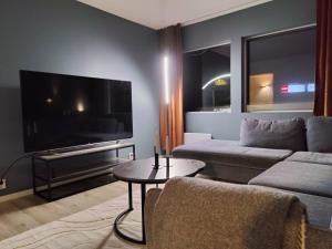 a living room with a couch and a flat screen tv at Appartement in Harstad 2 in Harstad