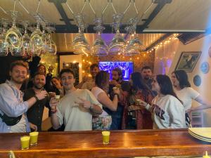 a group of people standing around a bar with drinks at Granada Hostel in Bogotá