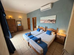 a bedroom with two beds with blue pillows at Villa Serenita in Xagħra +20 photos