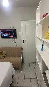 a small room with a bed and a tv on the wall at Suíte Standard Privado in Vitória