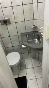 a bathroom with a toilet and a sink at Suíte Standard Privado in Vitória
