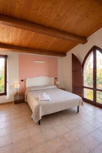a bedroom with a large bed with a wooden ceiling at Locanda Merlaschio in Faenza