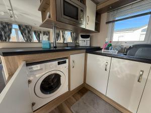 a kitchen with a washing machine and a sink at Sunset Serenity - 4 Sunset View in Crowle