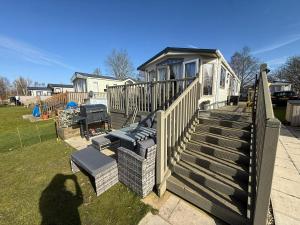 a house with a wooden deck with chairs on it at Sunset Serenity - 4 Sunset View in Crowle +6 photos