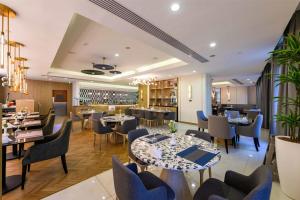 a restaurant with tables and chairs and a bar at DoubleTree by Hilton Jeddah - Alandalus Mall in Jeddah