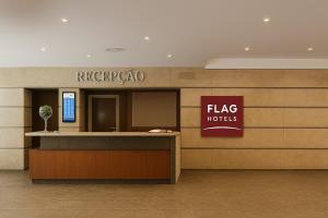 a lobby of a hotel with a flag hotel sign at Flag Hotel Campo Maior in Campo Maior
