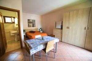 a bedroom with a table and a bed and a bathroom at Hotel La Maison Jolie in Fiumicino