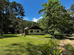 ein Haus inmitten eines Feldes mit Bäumen in der Unterkunft Hotel Refazenda in Visconde De Maua