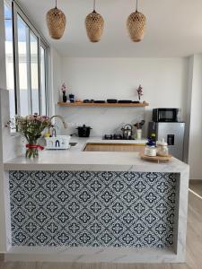 a kitchen with a white counter with a blue and white pattern at Ballestas Suite in Pisco