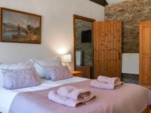 a bedroom with a bed with two towels on it at Byre Cottage - Uk50028 in Liskeard +5 photos