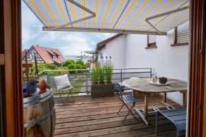 a patio with a table and chairs on a deck at Winzerlodge, Wohnung Kirchberg in Gleiszellen-Gleishorbach