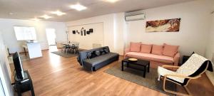 a living room with a couch and a tv at Driopon Apartment - Penthouse in Athens