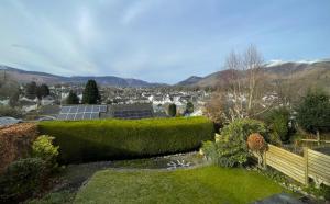 a garden with green hedges and a view of a city at 16 Manesty View in Keswick