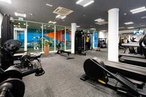 a gym with treadmills and machines in a room at Marina Suite in Loano