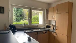 a kitchen with a sink and a large window at Ferienwohnung Karl May in Lennestadt