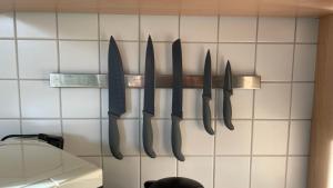 a group of knives hanging on a rack on a wall at Ferienwohnung Karl May in Lennestadt +12 photos