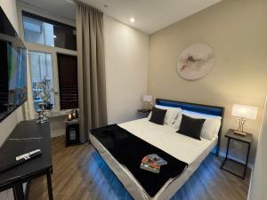 a bedroom with a bed and a desk and a window at MILUAR Relais - Piazza Fuga in Naples