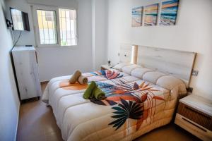 a bedroom with a bed with a colorful bedspread at Apto Primera Línea con Piscina - Guipas Beach in Puerto de Mazarrón