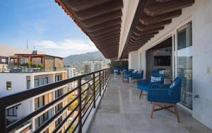 a balcony with chairs and tables on a building at Suites at Zona Romantica in Puerto Vallarta