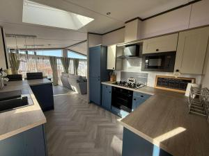 a kitchen with blue cabinets and a counter top at Cedar Lodge - 27 Sunset View in Crowle