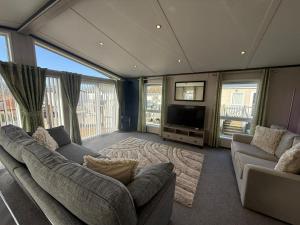 a living room with two couches and a television at Cedar Lodge - 27 Sunset View in Crowle