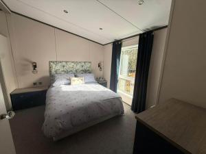 a bedroom with a bed and a large window at Cedar Lodge - 27 Sunset View in Crowle