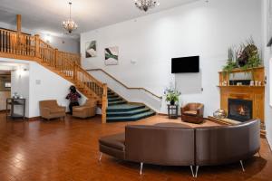 a living room with a couch and a staircase at All Seasons Resort in Kalkaska