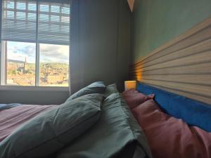 a bed in a bedroom with a large window at Sleep Eat Repeat Apartment in Macclesfield