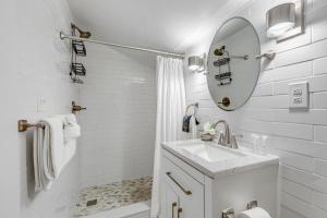a white bathroom with a sink and a mirror at HIDEAWAY @ Speakeasy Inn Key West! in Key West