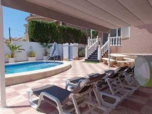 a group of lounge chairs next to a swimming pool at Casa de Limón in Ciudad Quesada