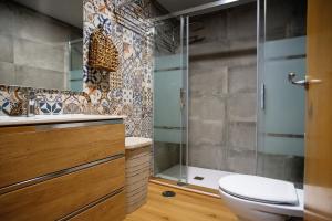 a bathroom with a toilet and a glass shower at Apto Primera Línea con Piscina - Guipas Beach in Puerto de Mazarrón +13 photos