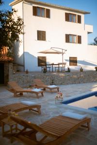 a building with a group of benches and a pool at Holiday Home Pearl in Stone in Imotski