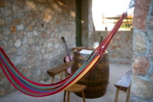 a hammock in a room with chairs and a stone wall at Holiday Home Pearl in Stone in Imotski