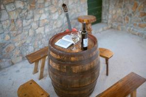 a barrel with a bottle of wine and two glasses at Holiday Home Pearl in Stone in Imotski