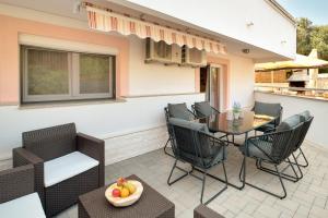a patio with chairs and a table with a bowl of fruit at APARTMANI SABB in Jezera
