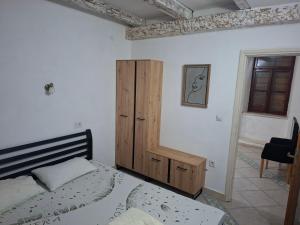 a bedroom with a bed and a wooden cabinet at Forteca home in Perast