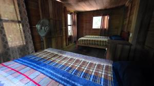a bedroom with two beds in a wooden cabin at Cabaña Tu´ur in Lacanjá