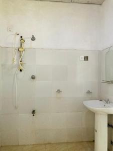 a bathroom with a shower and a sink at Ashi Hostel Sigiriya in Sigiriya