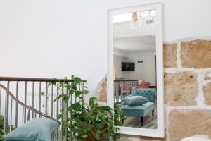 a mirror in a living room with a blue chair at Ire' Luxury Suite in Avola