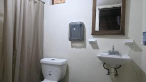 a bathroom with a toilet and a sink and a mirror at Cabaña Tu´ur in Lacanjá