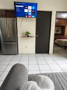a person laying on a bed in a kitchen with a refrigerator at Bonsai House in Ramos Arizpe