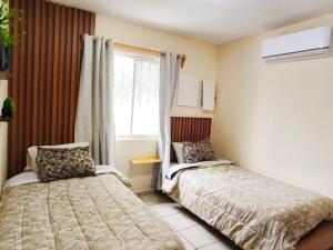 a bedroom with two beds and a window at Bonsai House in Ramos Arizpe
