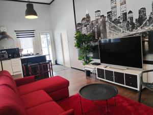 a living room with a red couch and a flat screen tv at Pihapiilo in Raahe